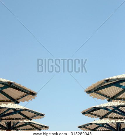 Six Hats Of Beach Umbrellas Against The Blue Sunny Sky In Summer