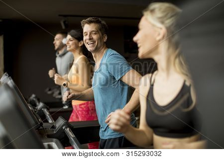 Young People Using Threadmill In Modern Gym
