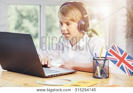Young Schoolboy Stydying Online English Using Laptop