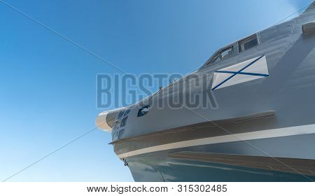 Nose Of Military Airplane With Ensign Of Russian Navy. Copy Space. Blue Sky Russian Background