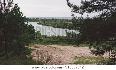Large Lake On A Sunny Day Against The Background Of A Dense Green Forest, Nature In Russia
