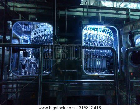 Parts Of Filling Bottles Machine In Drinking Production Factory.