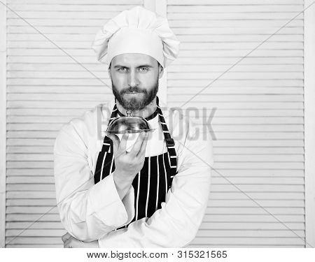 Man Cook Hat And Apron Hold Meal Covered With Lid. Delicious Meal Presentation. Haute Cuisine Charac