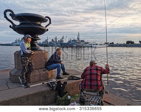 Saint-petersburg, Russia - July 23, 2019: Fishermen Catch Fish In Kronstadt, On The Background Of Wa
