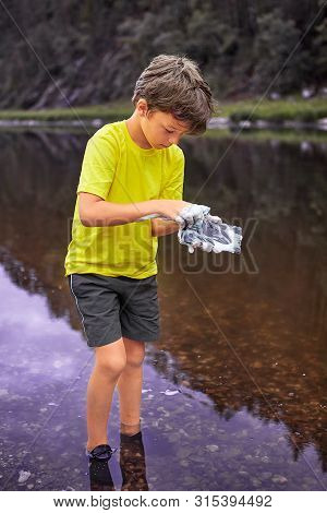 White Wet  Boy About 8 Years Old Is Standing In River And Washing Mobile Phone Using Foam Of Soap, H