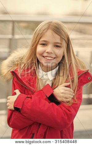 Kid Smiling Girl Wear Coat Jacket With Fur On Hood But Feels Cold. Cold Weather Concept. She Is Free