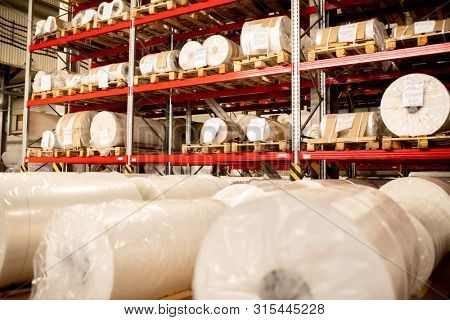 Rows of rolled and packed newly produced huge bobbins of polyethylene membrane