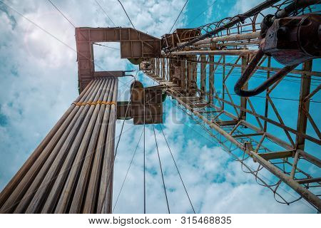 Oil And Gas Drilling Rig Onshore Dessert With Dramatic Cloudscape. Oil Drilling Rig Operation On The