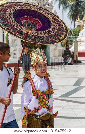 Yangon, Myanmar-may 6th 2014: Boy Dressed For Religious Ceremony In Shwedagon Pagod. The Pagoda Is T