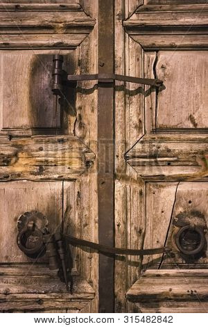 Old wooden door of entrance to the Church of the Holy Sepulchre, also called the Church of the Resurrection or Church of the Anastasis, in Old City of Jerusalem, Israel
