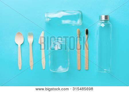 Bamboo Toothbrushes Wooden Cutlery Glass Bottle Jar On Blue Background. Zero Waste Plastic Free Eco 