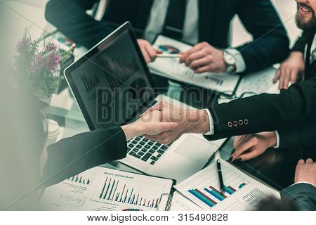 Handshake Of Business Partners On The Background Of The Financia