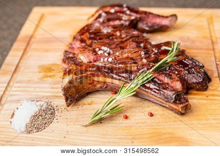 Food And Horse Meat Concept - Roast Meat On Cutting Board With Cumin