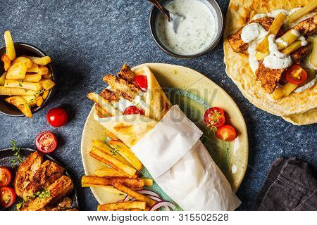 Gyros Souvlaki Wraps In Pita Bread With Chicken, Potatoes And Tzatziki Sauce, Blue Background, Top V