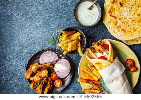 Gyros Souvlaki Wraps In Pita Bread With Chicken, Potatoes And Tzatziki Sauce, Blue Background, Top V