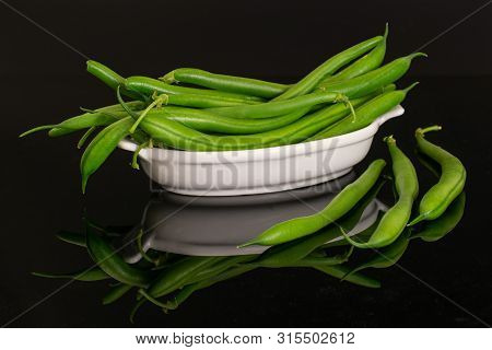 Lot Of Whole Fresh Green Bean Three Are Aside And The Rest Is In White Oval Ceramic Bowl Isolated On