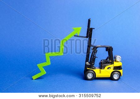 A Yellow Forklift Raises A Big Green Arrow Up. Growth In Production Rates And Development Of Industr