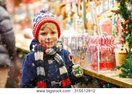 Little Cute Kid Boy Buying Sweets From A Cancy Stand On Christmas Market. Happy Child On Traditional