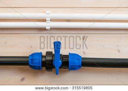 White And Black Water Pipes On A Light Wooden Wall