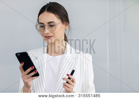 Business Woman With Phone On Street. Portrait Of Smiling Beautiful Young Female In Stylish Clothes C