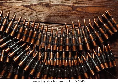 Bullets On A Wooden Background. Military Concept.
