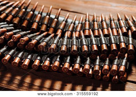 Bullets On A Wooden Background. Military Concept.