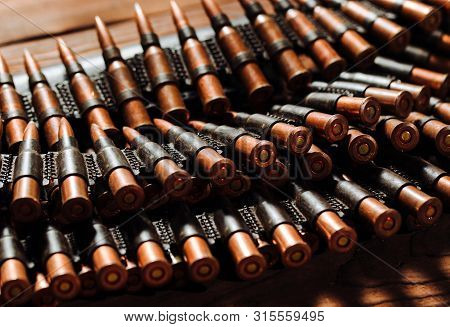 Bullets On A Wooden Background. Military Concept.