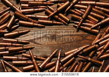 Bullets On A Wooden Background. Military Concept.
