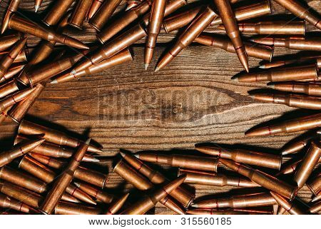 Bullets On A Wooden Background. Military Concept.