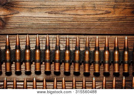 Bullets On A Wooden Background. Military Concept.