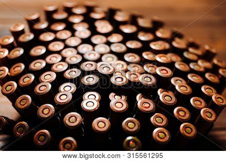 Bullets On A Wooden Background. Military Concept.