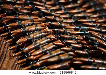 Bullets On A Wooden Background. Military Concept.