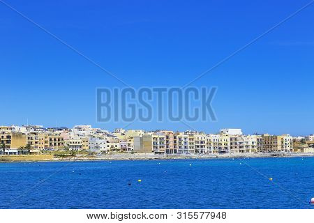 Pretty Bay Beach In Birzebbuga With Colorful Houses On Coastline, Sandy Beach And Mediterranean Sea,
