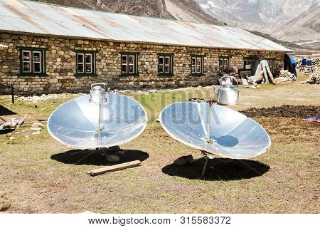 Warming The Teapot In A Solar Cooker. Ecology Concept. Renewable Green Energy. Nepal. Himalaya.