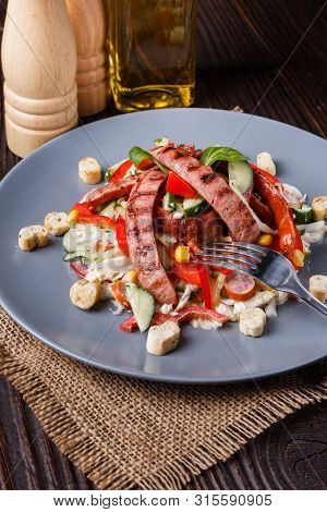 Salad With Grilled Sausage Paprica Cucumber And Croutons