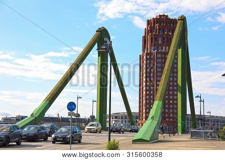 Frankfurt, Germany - June 13, 2019: Flosserbrucke Bridge And Lindner Hotel & Residence Main Plaza On