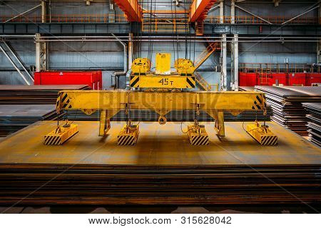 Overhead Crane With Electromagnetic Beam Grippers Lifting Steel Sheets.