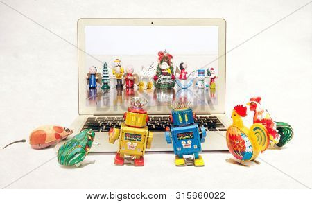 retro tin toys looking at a there friends celerbrating Christmas on a laptop computer