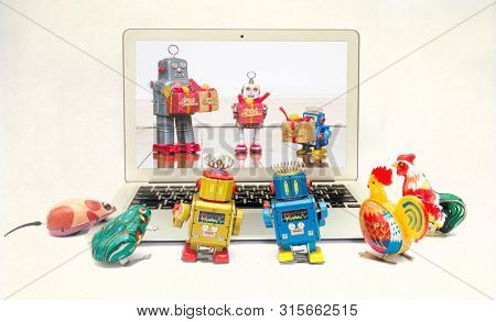 retro tin toys looking at a there friends celerbrating Christmas on a laptop computer 