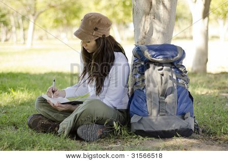 Escritura en diario de viaje de la mujer joven