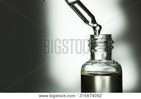 Cosmetic Or Medical Glass Bottle With Pipette. Skin Care Concept. Natural Hard Light, Deep Shadows. 