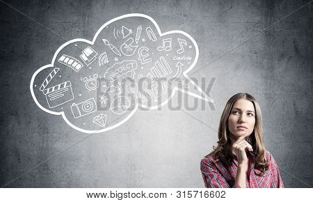 Serious Woman Looks Pensive Upwards And Thinking Something. Speech Bubble Full Of Business Diagrams 