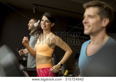 Young People Using Threadmill In Modern Gym