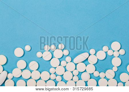Pharmacy Theme. White Different  Pills And Capsules On The Blue Surface. Closeup