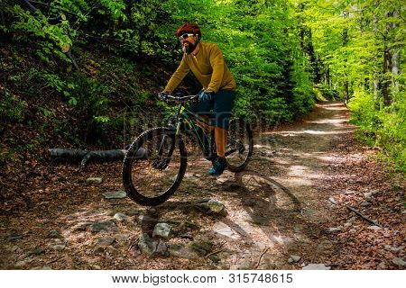 Cycling man riding on bike at sunset mountains forest landscape. Cycling MTB enduro flow trail track. Outdoor sport activity.