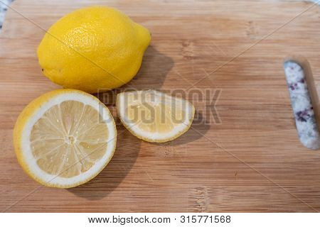 A Cut Lemon On A Wooden Cutting Board Ready For A Drink.
