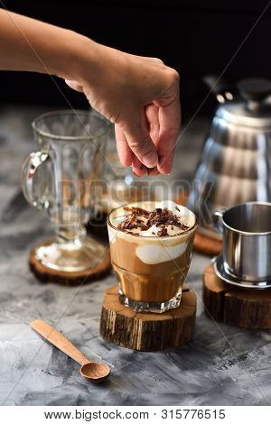 Making Coffee Cocktail. Slender Woman Hand Decorating Coffee With Chocolate Shaves In Short Glass On