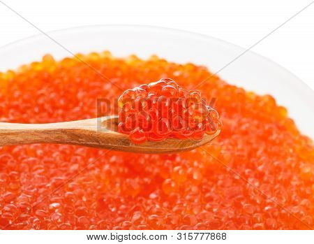 Little Wooden Spoon With Salted Russian Red Caviar Of Sockeye Salmon Fish Over Plastic Container Wit