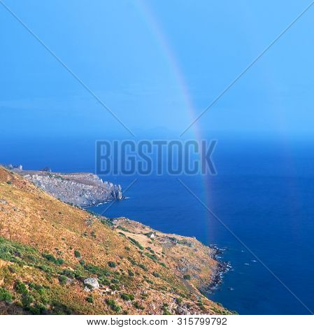 Wild Hilly Coastline Of Creta Island After A Rain With A Rainbow, Square Composition