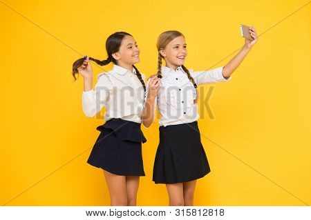 One More Selfie. Happy Schoolchildren Taking Selfie With Smartphone On Yellow Background. Little Gir